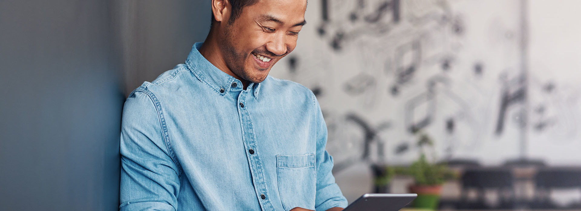 Un homme souriant en regardant sur sa tablette la plateforme easyprojets.com