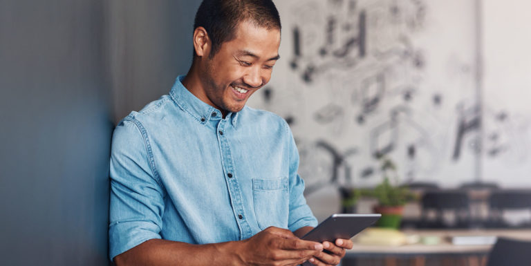 Un homme souriant en regardant sur sa tablette la plateforme easyprojets.com