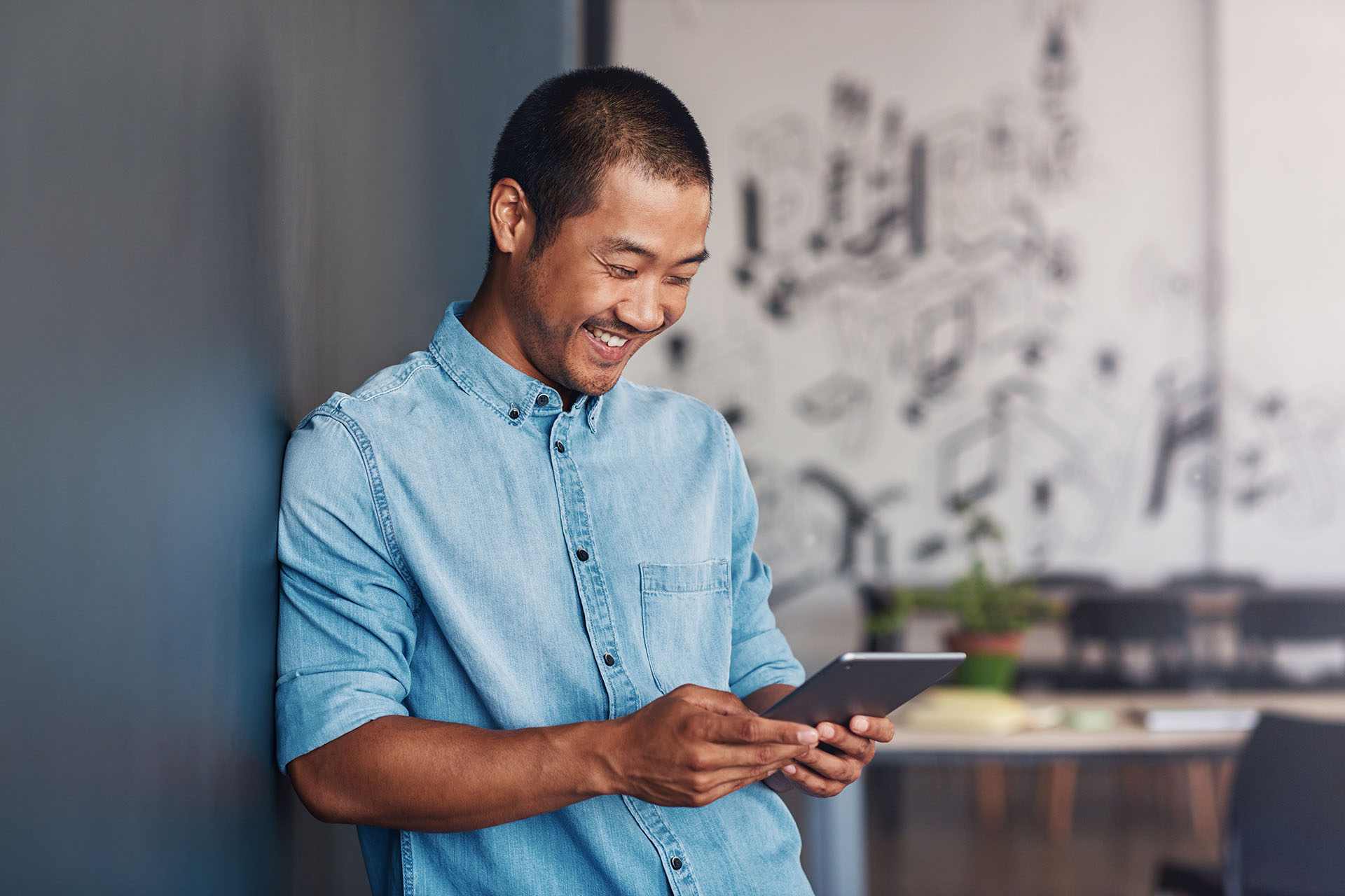 Un homme souriant en regardant sur sa tablette la plateforme easyprojets.com