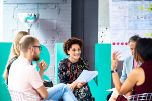 Un groupe de collègues discutant et souriant assis en cercle