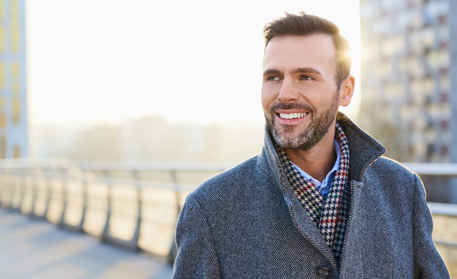 Un homme dans la rue regardant au loin et souriant - un médecin même à l'étranger grâce à la téléconsultation médicale