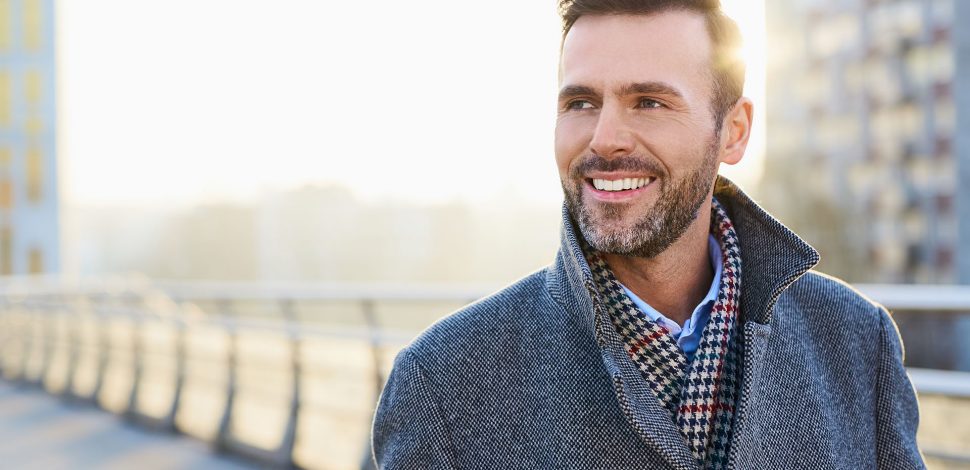 Un homme dans la rue regardant au loin et souriant - un médecin même à l'étranger grâce à la téléconsultation médicale