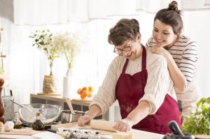 Une mère et sa fille proche aidante faisant la cuisine ensemble - dépendance