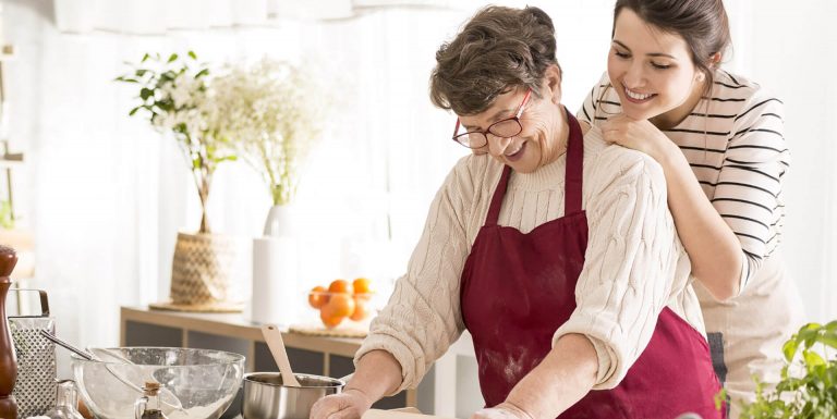 Une mère et sa fille proche aidante faisant la cuisine ensemble - dépendance