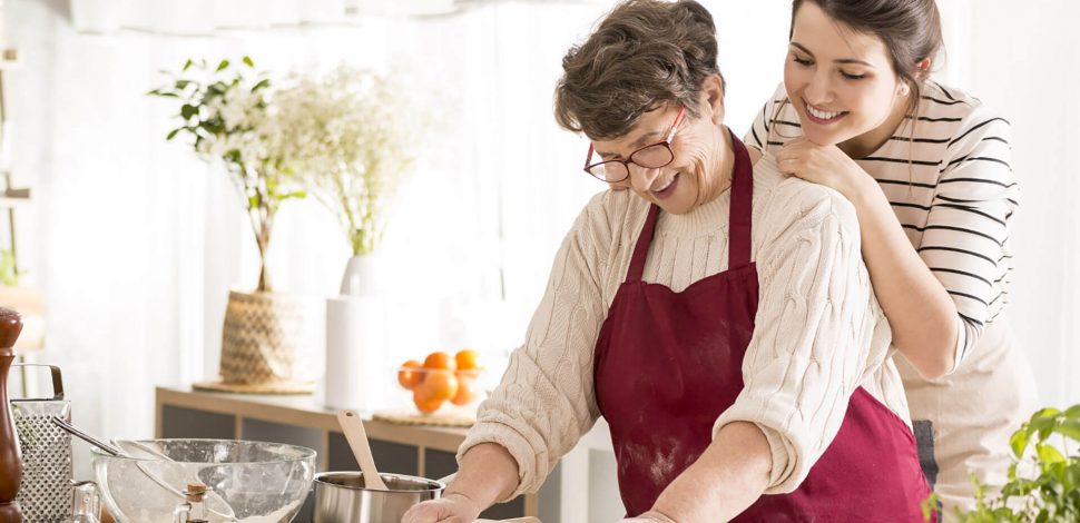 Une mère et sa fille proche aidante faisant la cuisine ensemble - dépendance