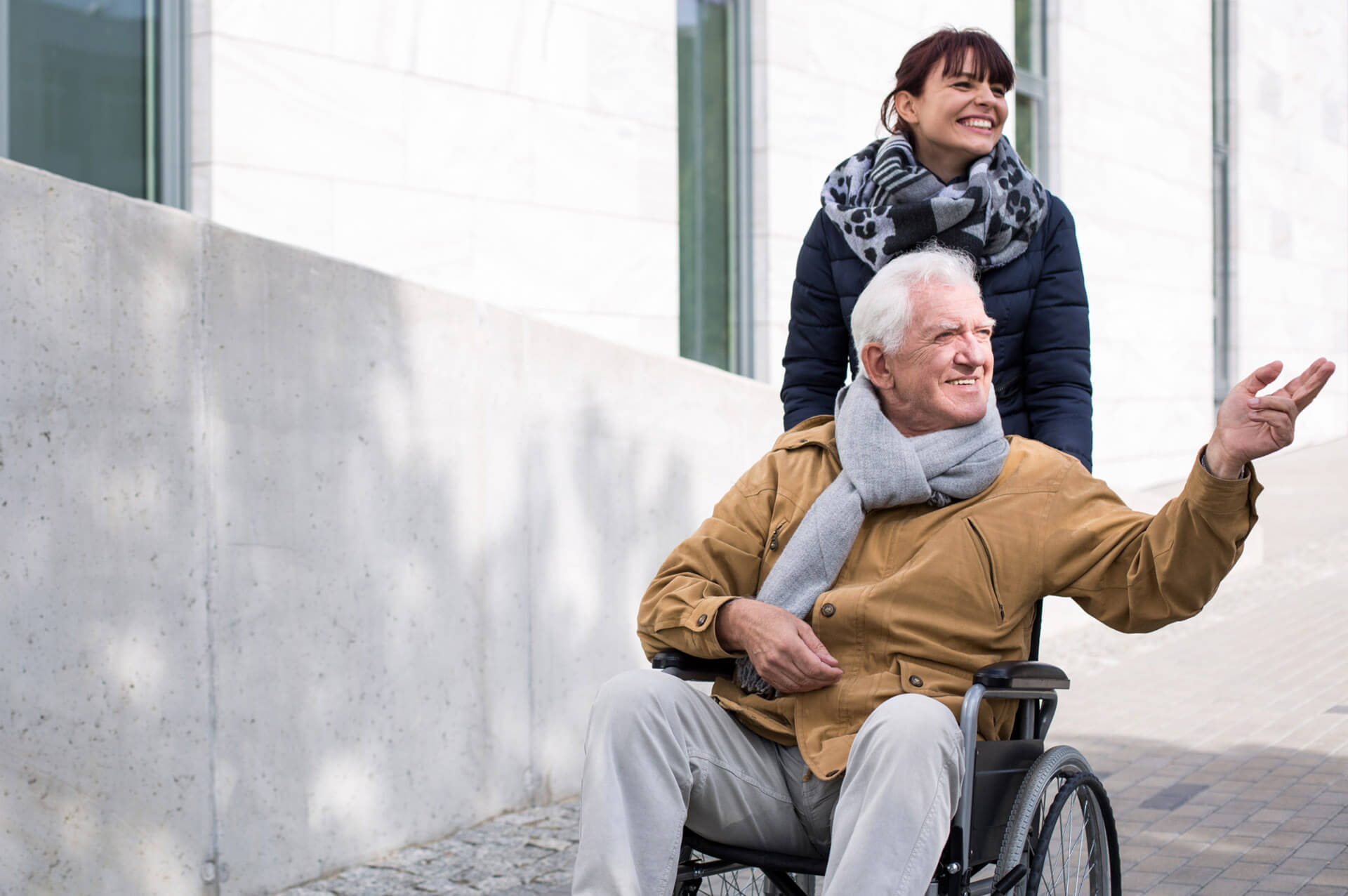 Une fille rigolant poussant son père dépendant en fauteuil roulant