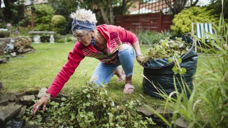 Une femme ramassant des herbes dans son jardin - financer ses projets pour une retraite occupée