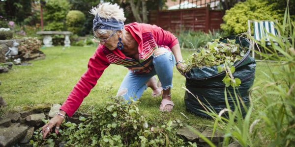 Une femme ramassant des herbes dans son jardin - financer ses projets pour une retraite occupée
