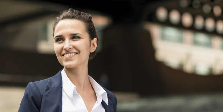 Une femme au travail souriant et regardant au loin