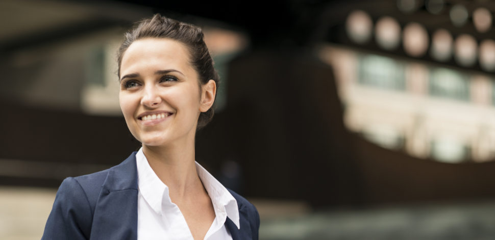 Une femme au travail souriant et regardant au loin