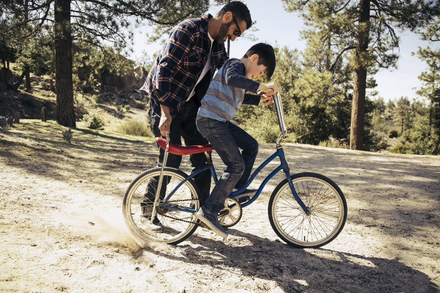Un père apprenant à son fils à faire du vélo