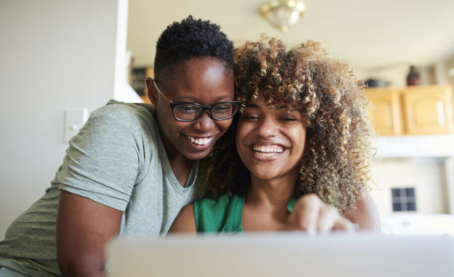 Deux femmes souriantes regardant sur leur ordinateur leurs contrats santé adaptés à la réforme 100% santé