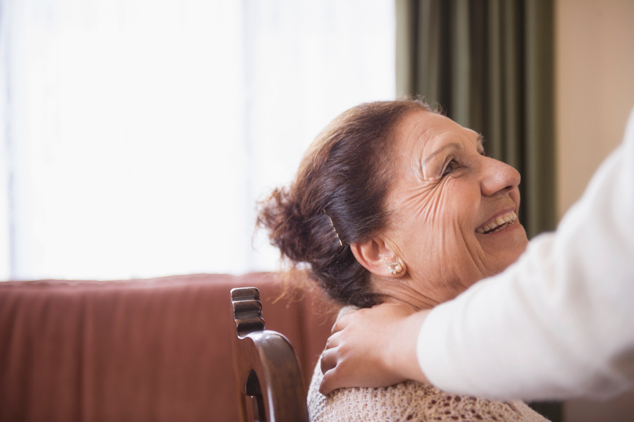 Une femme dépendante senior souriant en compagnie de son aidant