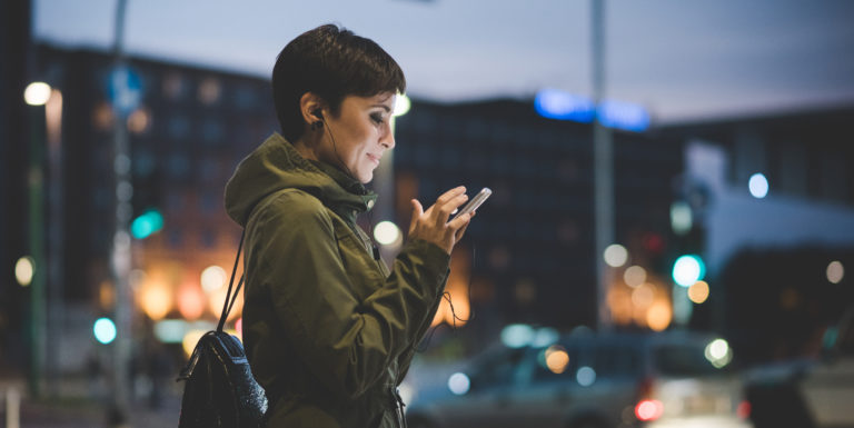 Une femme expatriée dans la rue sur son téléphone