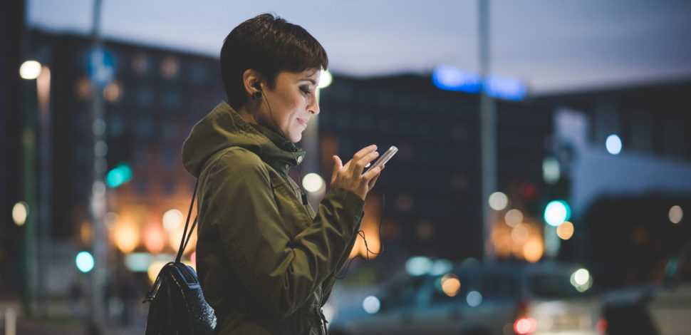 Une femme expatriée dans la rue sur son téléphone