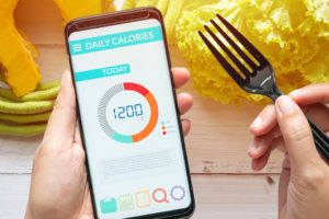 Un téléphone dans les mains d'une personne et montrant une application nutrition