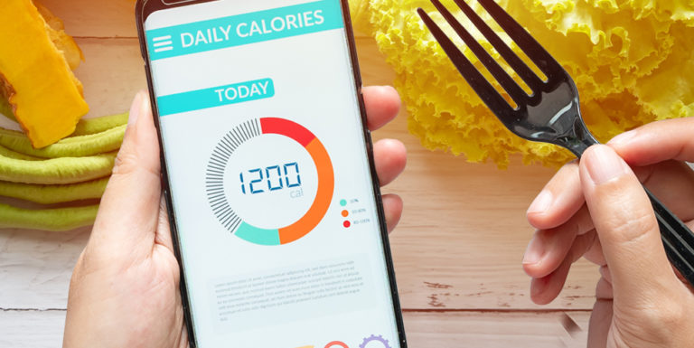 Un téléphone dans les mains d'une personne et montrant une application nutrition