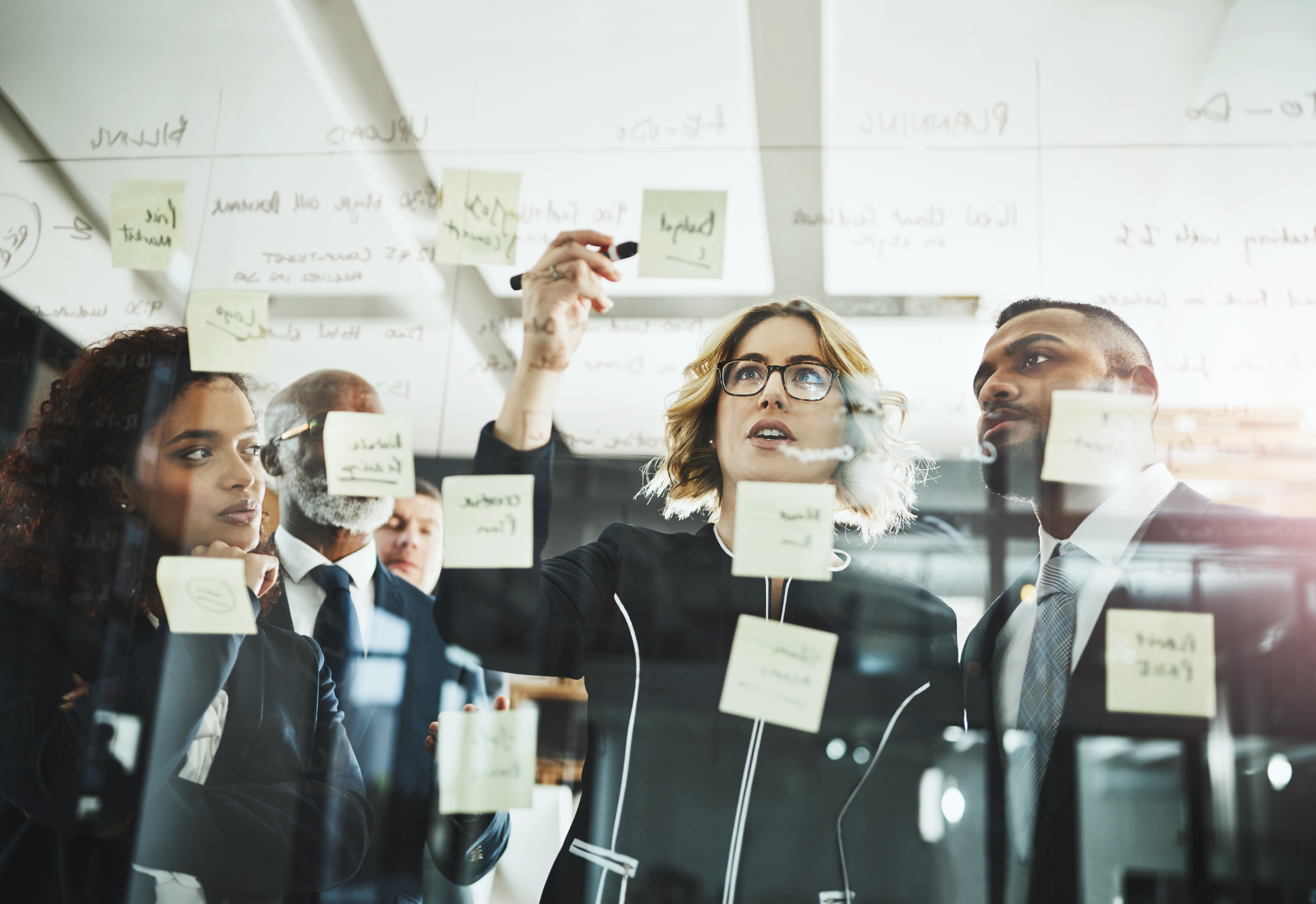 Plusieurs collègues discutant et travaillant à l'aide de post-it