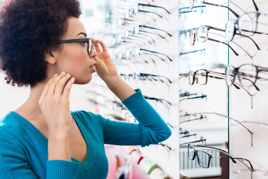 Une femme choisissant ses lunettes -100% santé optique