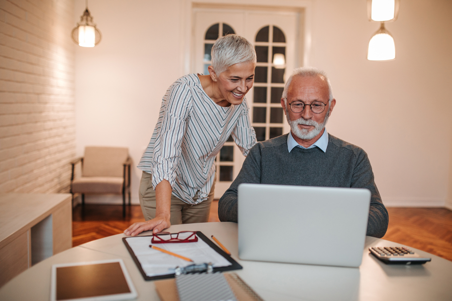 Un couple de sénior regardant sur leur ordinateur comment changer de complémentaire santé