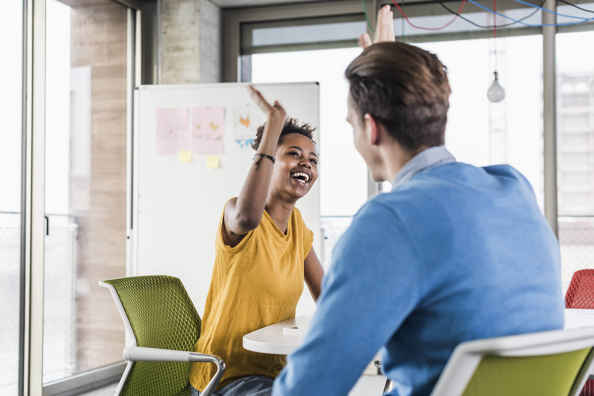 Un homme et une femme se tapant avec enthousiasme dans la main en entreprise Un homme et une femme se tapant avec enthousiasme dans la main en entreprise