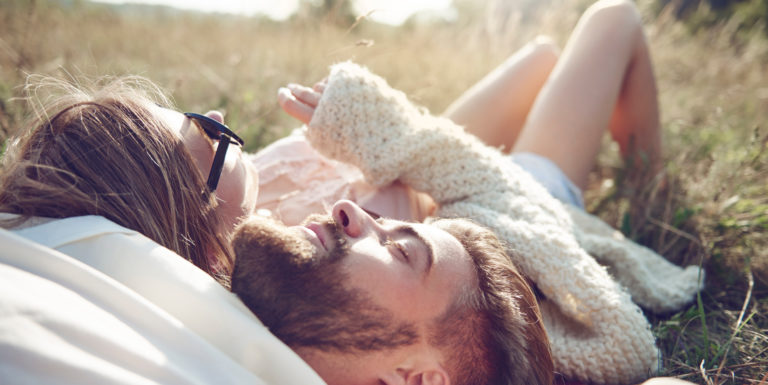 Un couple allongé dans l'herbe - mariage et pacs