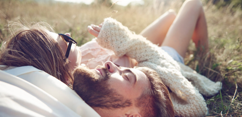 Un couple allongé dans l'herbe - mariage et pacs