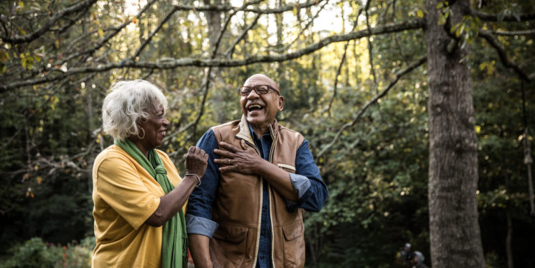 Un homme et une femme sénior rigolant ensemble dans le jardin