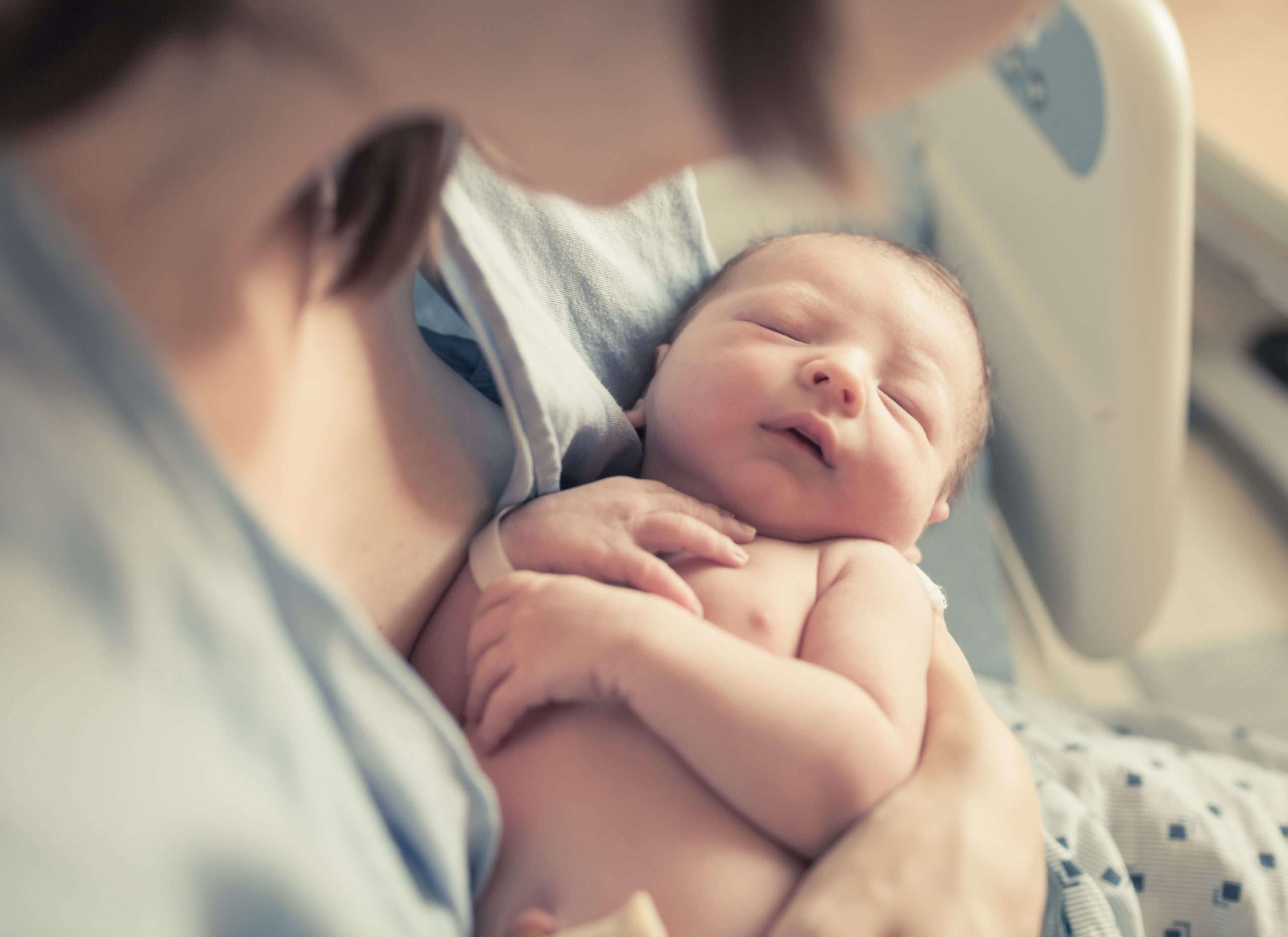 Un bébé dans les bras de sa mère à l'hôpital durant le congé maternité
