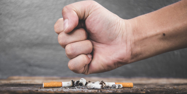 Un poing fermé écrasant une cigarette pour le mois sans tabac - cancer