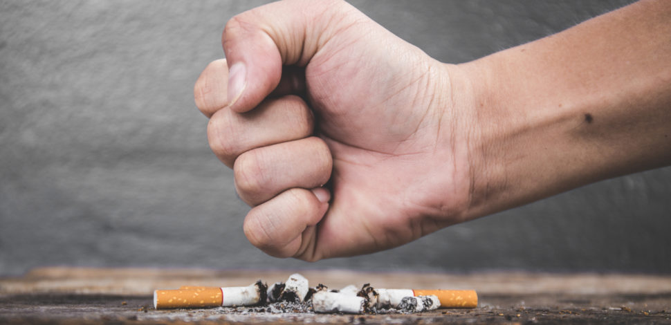 Un poing fermé écrasant une cigarette pour le mois sans tabac - cancer