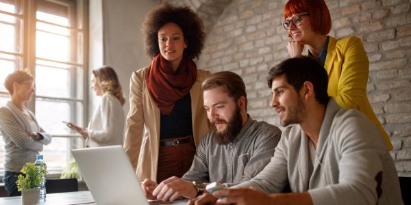 Un groupe d'hommes et de femmes ensemble les avantages du nouveau PER entreprise sur un ordinateur