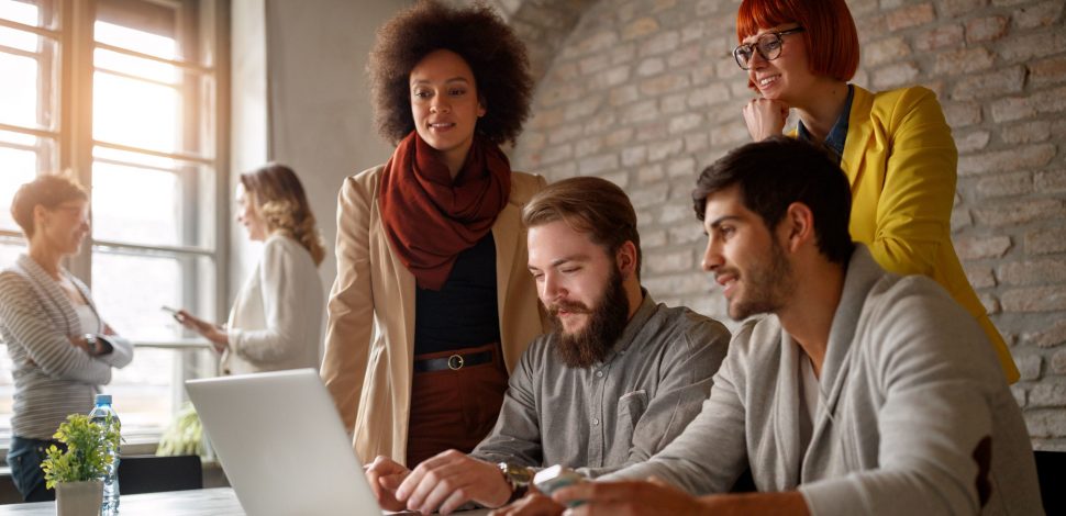 Un groupe d'hommes et de femmes ensemble les avantages du nouveau PER entreprise sur un ordinateur