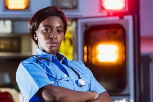 Une femme urgentiste aux USA les bras croisés et regardant l'objectif - système santé