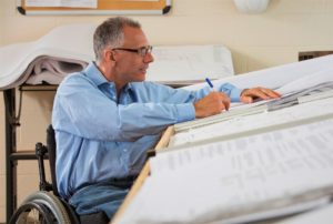Un homme en fauteuil roulant travaillant à son bureau - tiers payant intégral