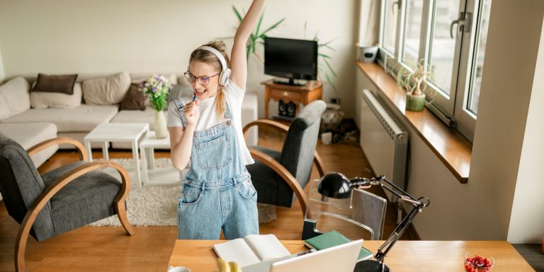 Une jeune stagiaire heureuse de découvrir ses droits en matière de protection sociale et chantant dans son salon