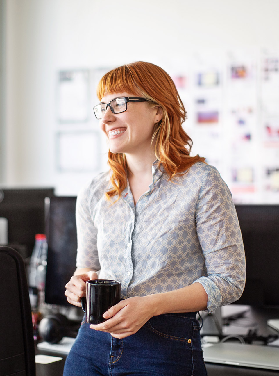 Une femme souriante en entreprise tenant sa tasse dans les mains - régimes article 39