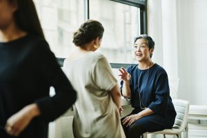 Deux femmes souriantes discutant ensemble de la retraite supplémentaire au travail