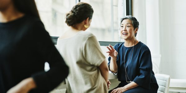 Deux femmes souriantes discutant ensemble de la retraite supplémentaire au travail