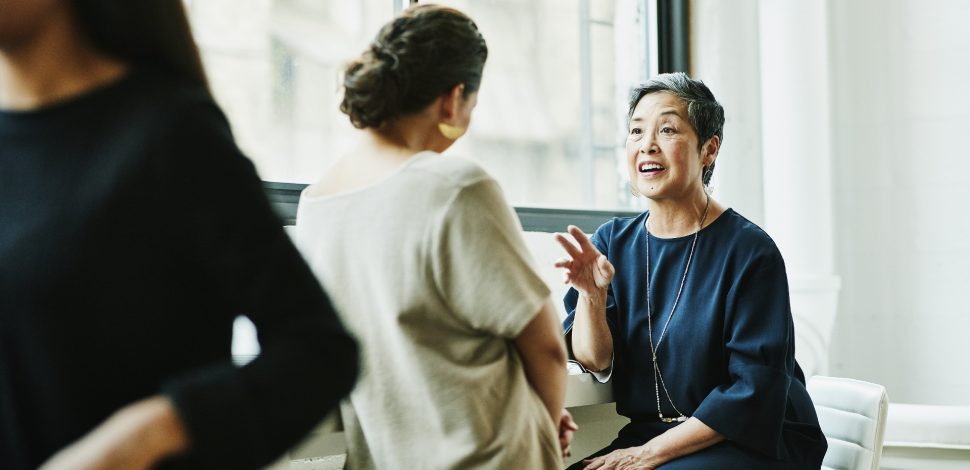 Deux femmes souriantes discutant ensemble de la retraite supplémentaire au travail