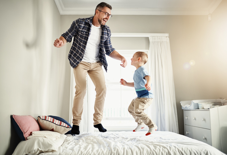 Un père et son enfant sautant sur le lit - clause bénéficiaire