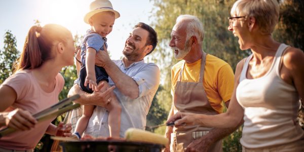 Une famille souriant et profitant d'un barbecue au soleil - clause bénéficiaire