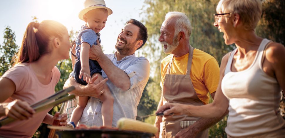 Une famille souriant et profitant d'un barbecue au soleil - clause bénéficiaire