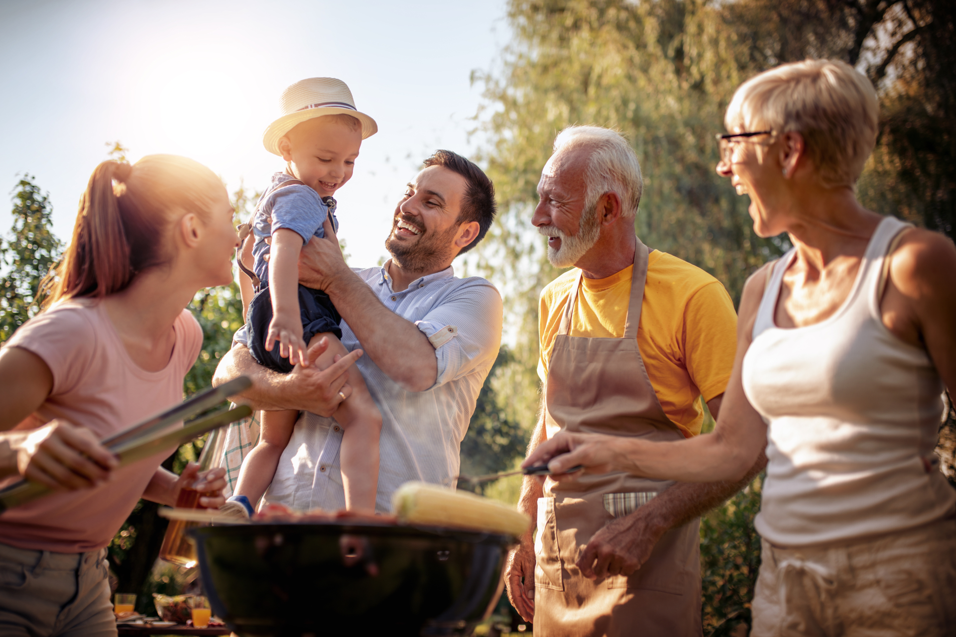 Une famille souriant et profitant d'un barbecue au soleil - clause bénéficiaire