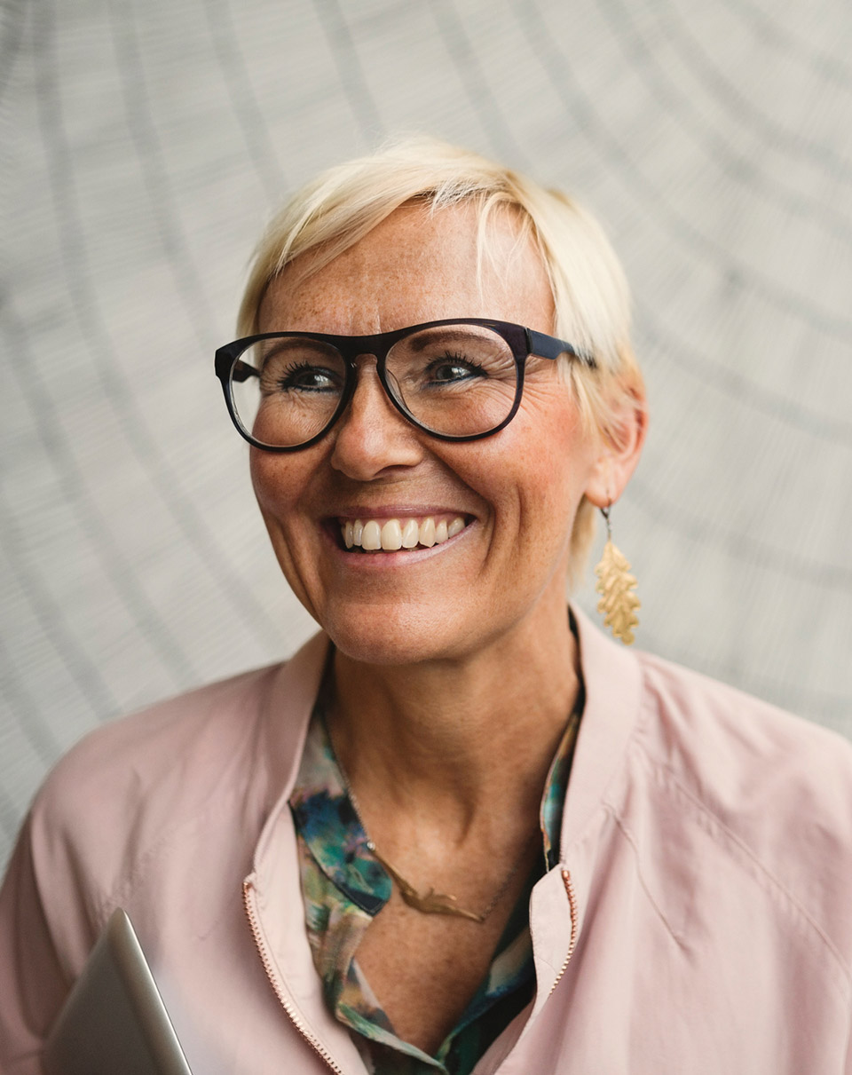 Une femme senior portant des lunettes et souriant - qualité de vie au travail