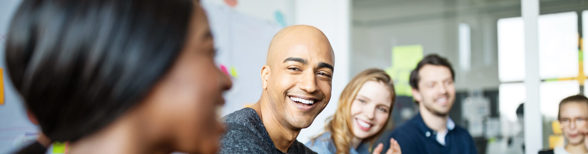 Groupe d'hommes et de femmes diverses souriant et parlant en réunion du PER Unique