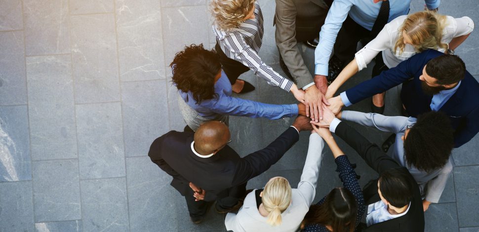 Une équipe réunissant ses mains au centre du cercle - indicateurs ESG