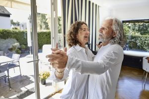 Un couple profitant de leur retraite supplémentaire dansant ensemble et riant