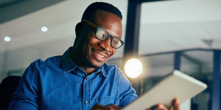 Un homme portant des lunettes regardant le rapport sur la santé mentale en Afrique sur sa tablette