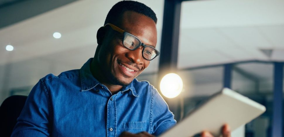 Un homme portant des lunettes regardant le rapport sur la santé mentale en Afrique sur sa tablette